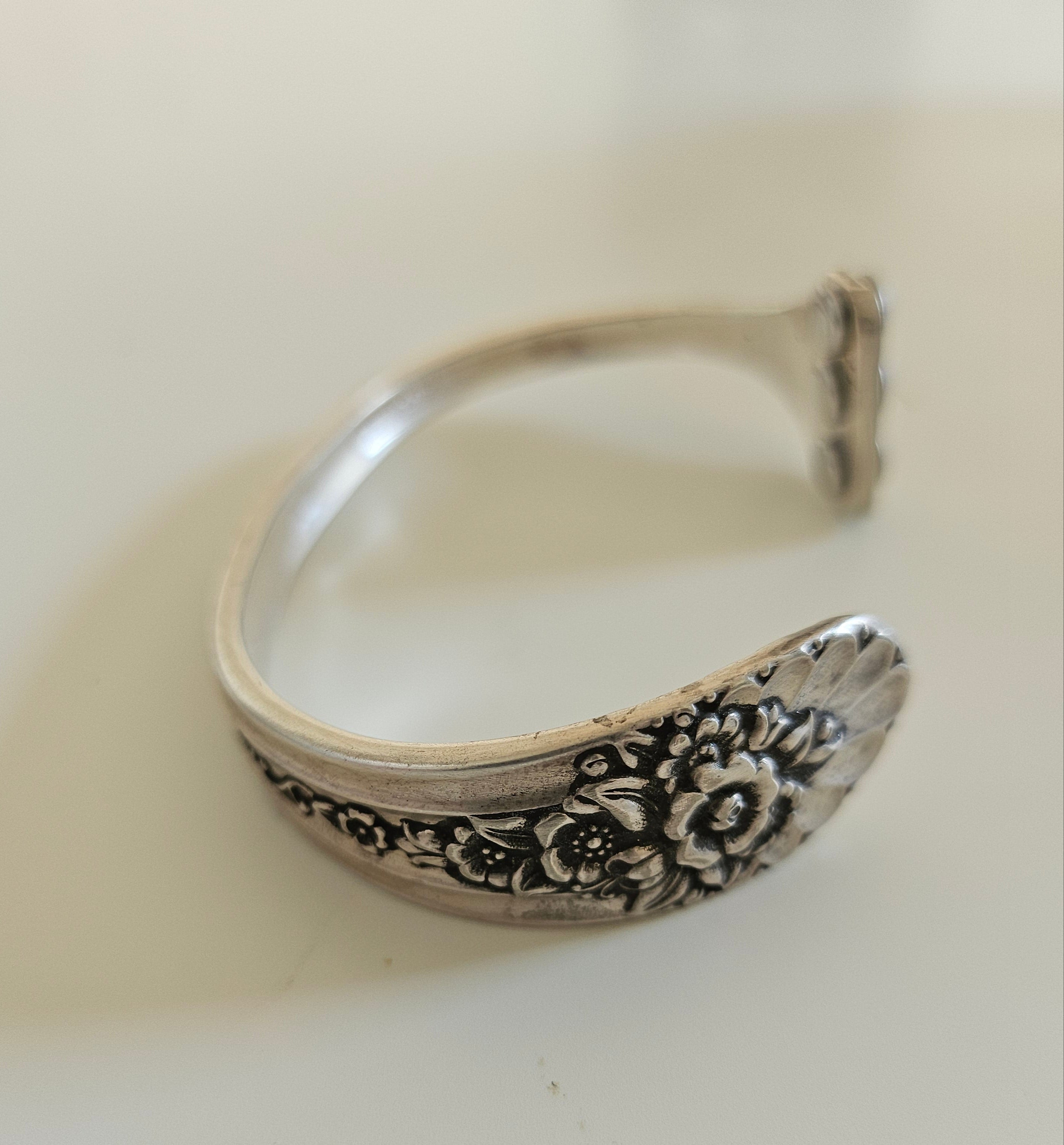 Handcrafted from 1953 Jubilee silverware, this vintage cuff bracelet features delicate floral details and pink crystals for a timeless, romantic sparkle