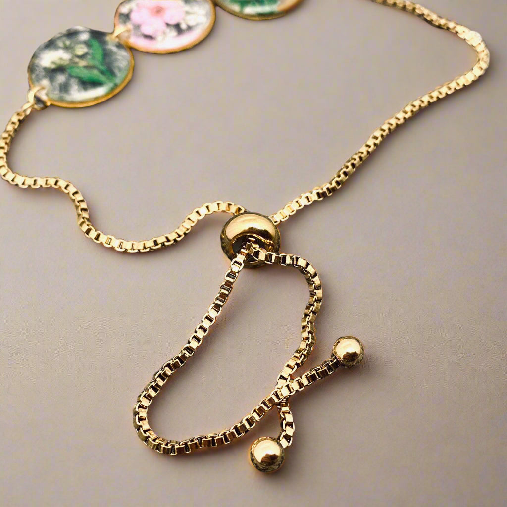 Handmade floral charm bracelet with real pressed Baby’s Breath, Daffodil, Queen Anne’s Lace, and Fern in resin. Adjustable 18K gold-plated stainless steel chain.