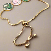 Handmade floral charm bracelet with real pressed Baby’s Breath, Daffodil, Queen Anne’s Lace, and Fern in resin. Adjustable 18K gold-plated stainless steel chain.