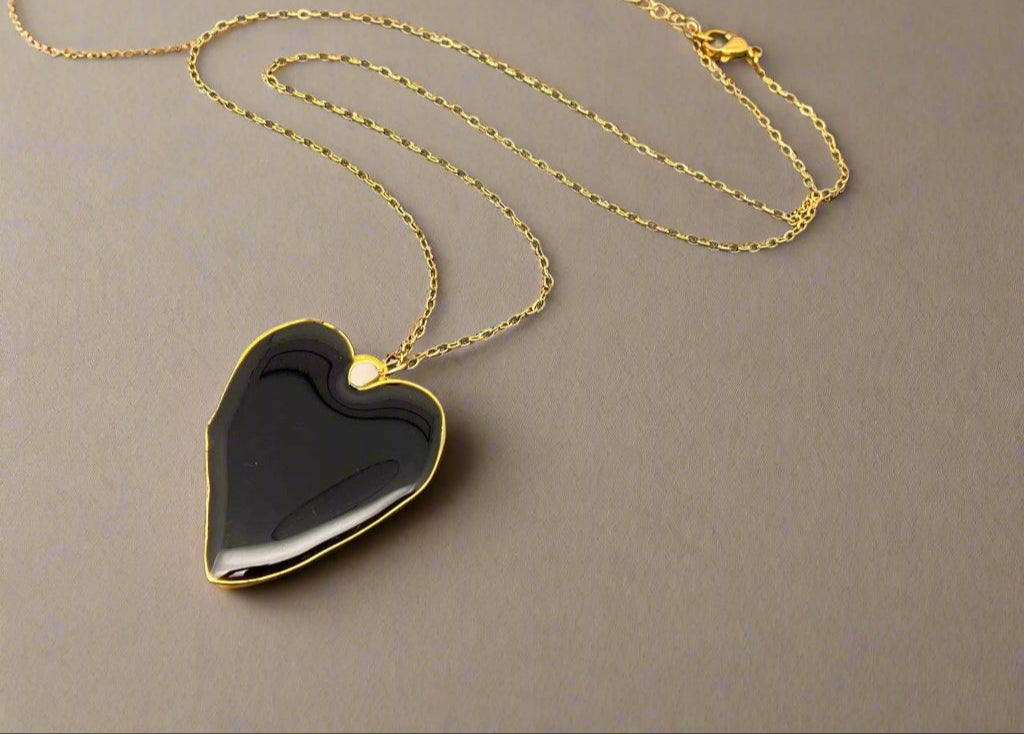 Heart-shaped necklace with real pressed flowers in resin, set in 18K gold-plated copper. Unique, handmade botanical jewelry with stainless steel chain.