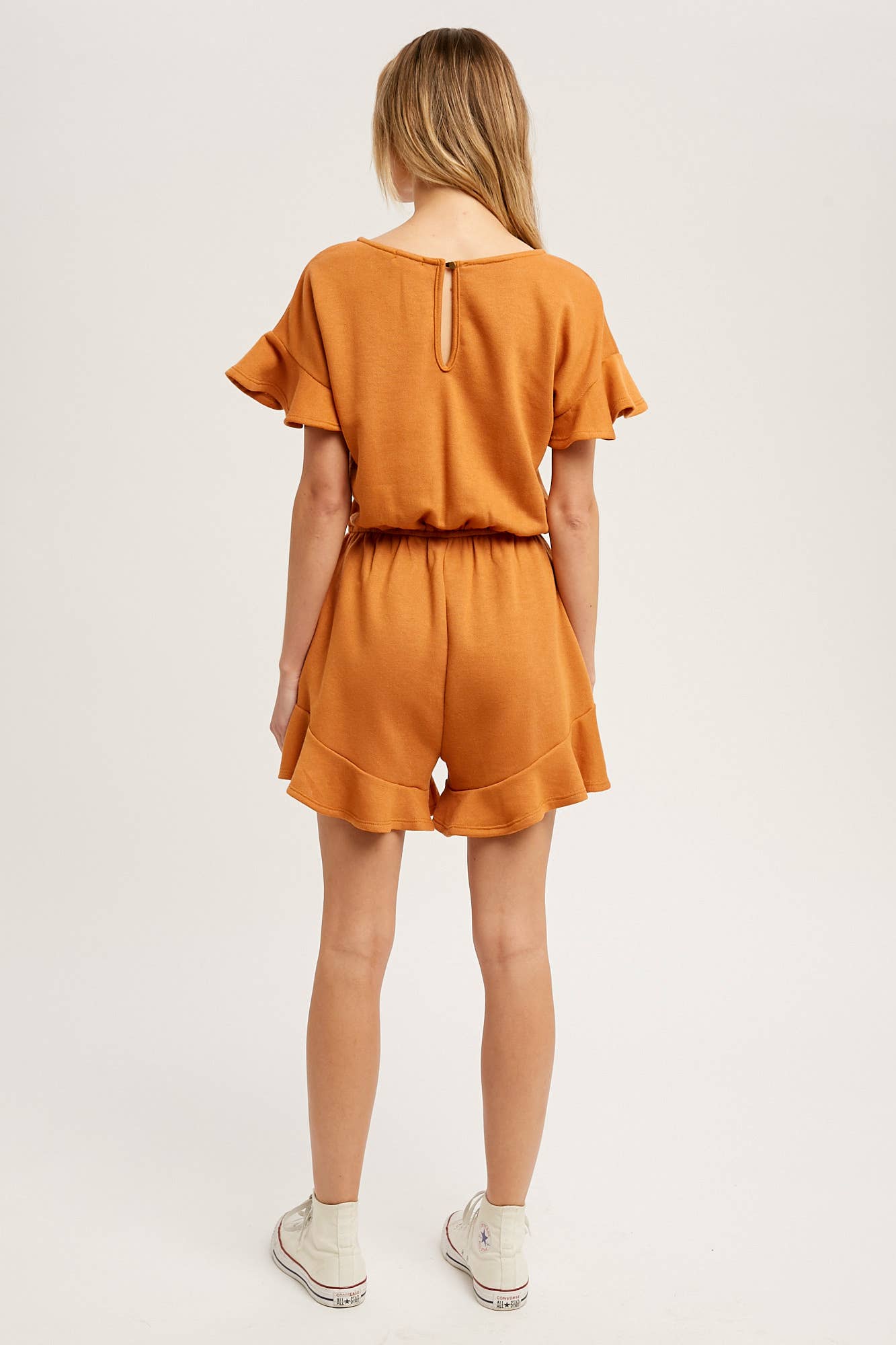 Soft French terry romper with ruffled sleeves, elastic waist, pockets & back button closure. Comfy, cute, and perfect for sunny days or casual outings.