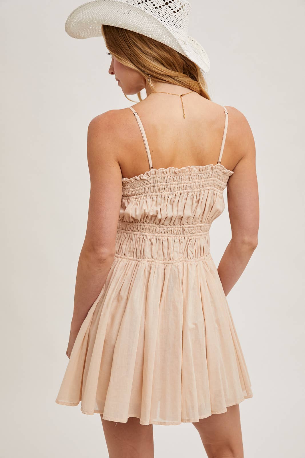 Smocked mini dress with button-down front, adjustable straps & breezy skirt. A flattering, lightweight style perfect for summer days & casual outings.