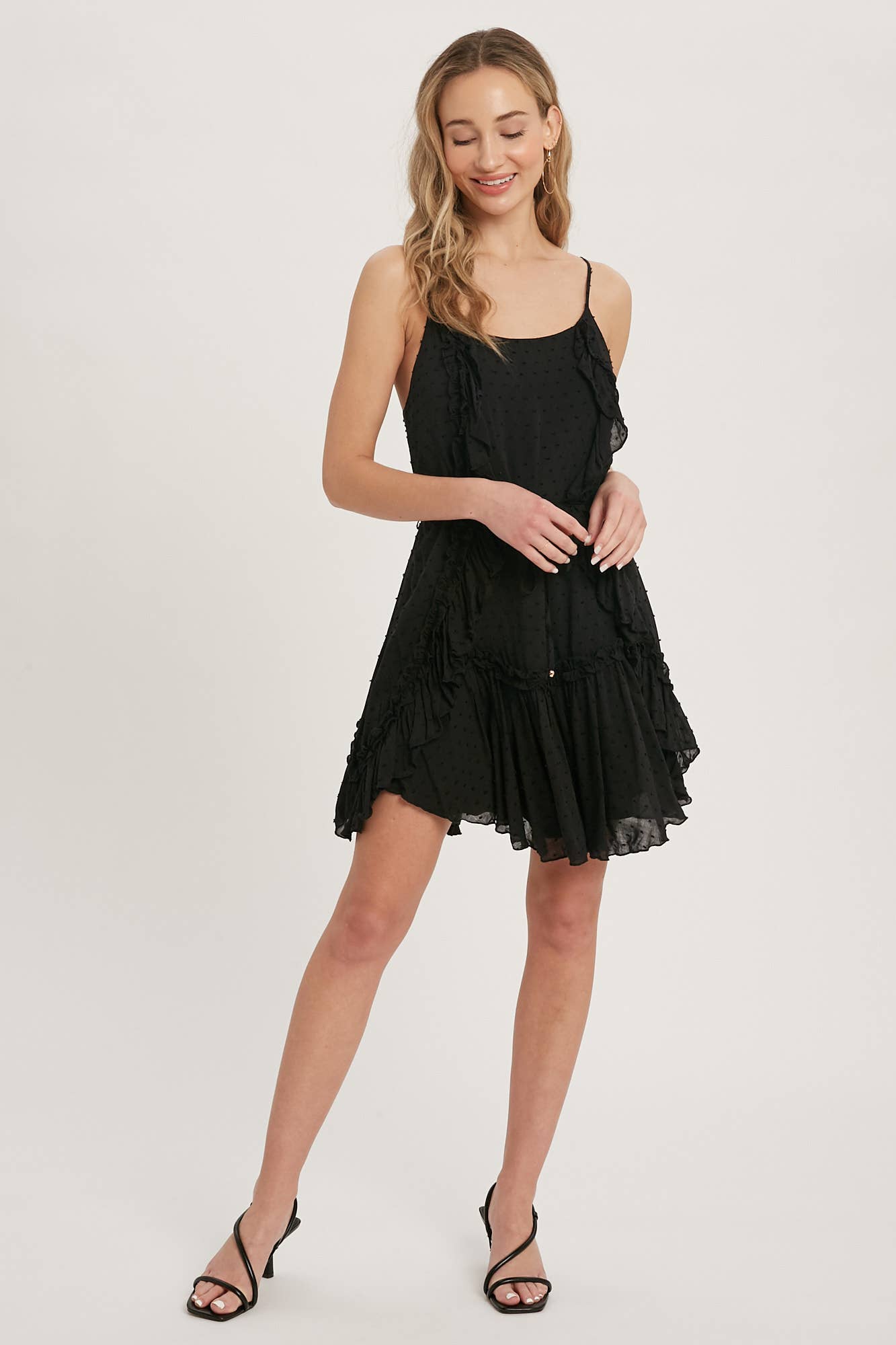 Swiss dot mini dress with ruffle details, lace-up back, adjustable straps & waist tie. Lightweight rayon, perfect for warm days & effortlessly chic looks.