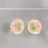 Blushing Bloom earrings feature real pink delphinium and Queen Anne’s Lace in clear resin with copper frames—lightweight, romantic, and naturally one-of-a-kind.