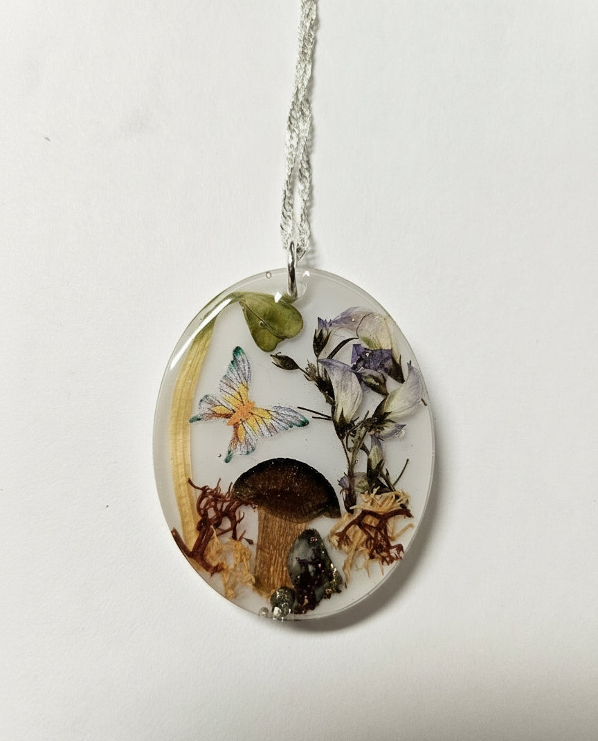 Handcrafted terrarium necklace featuring preserved botanicals and moss, creating a miniature garden you can wear. Each piece is one of a kind.