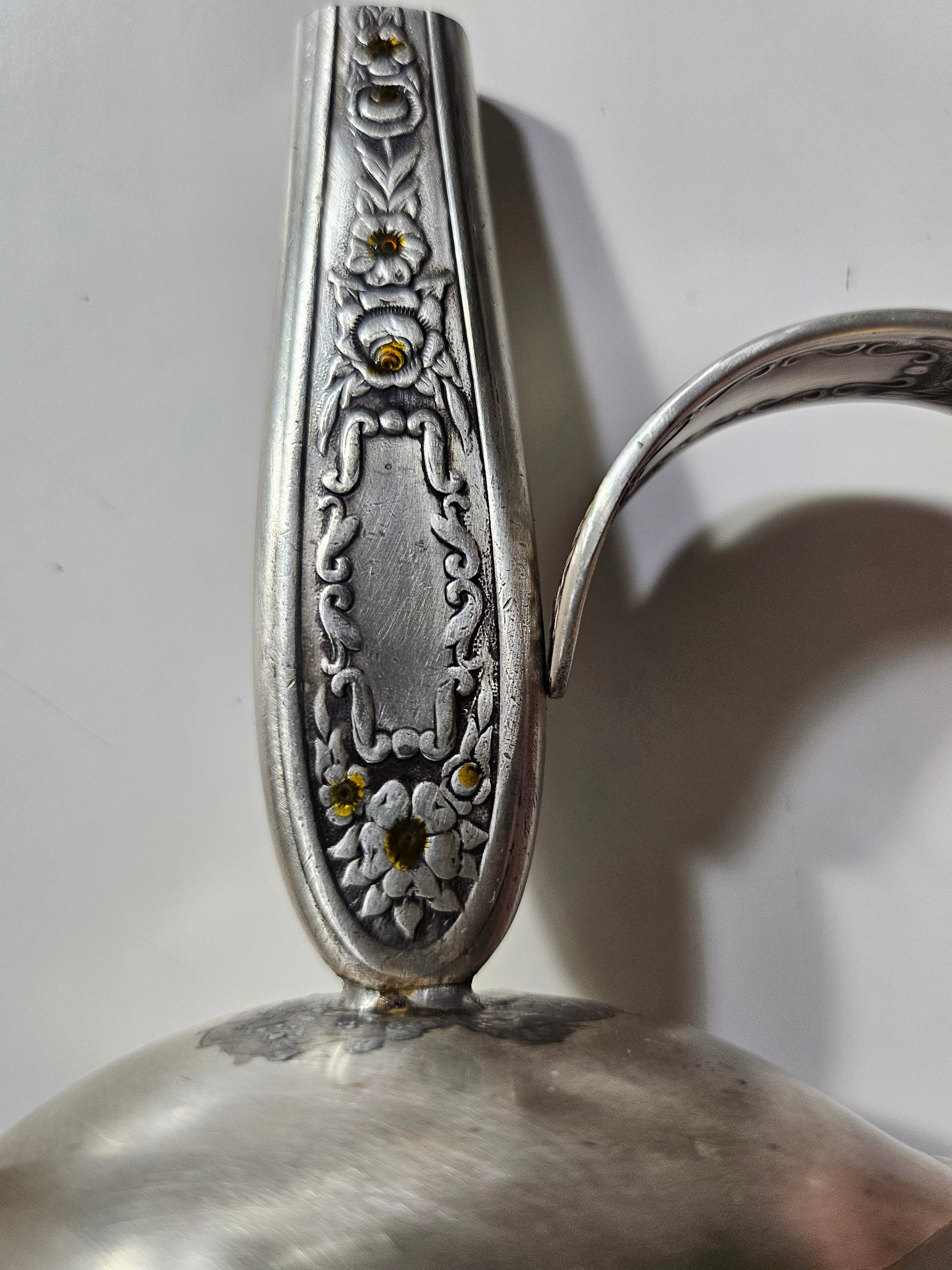 The Salvaged Silver Vintage Bud Vase is a handcrafted décor piece made from authentic Mildred 1936 antique silverware. Repurposed with artistry, it blends vintage charm with sustainability. Each vase is unique, making it a timeless accent for any space. A perfect gift for collectors and eco-conscious decorators, bringing history to modern homes.