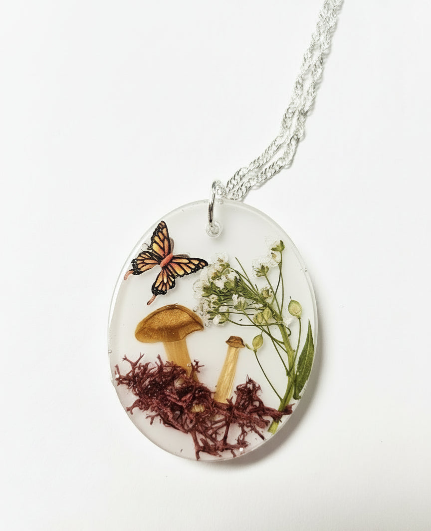 Handcrafted terrarium necklace featuring preserved botanicals and moss, creating a miniature garden you can wear. Each piece is one of a kind.