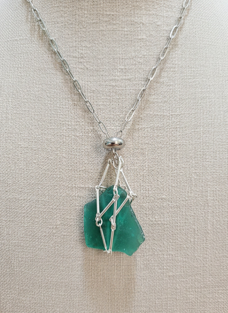 A versatile Crystal and Rock Cage Necklace with an adjustable metal pendant. Swap in your favorite gemstones or charms for a personalized, mystical accessory.