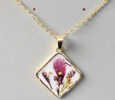Handcrafted square pendant necklace with real pressed dried flowers in clear resin. Unique botanical jewelry with stainless steel chain and copper frame.