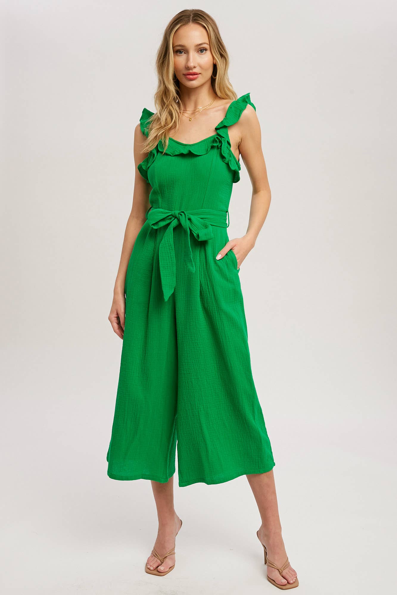 Chic textured cotton jumpsuit with frill trim, wide-leg fit, side pockets, self-tie waist, and back zipper. A relaxed, flattering one-piece for any season.