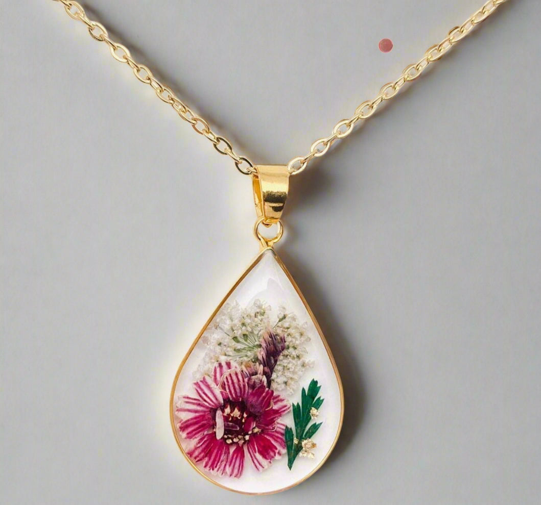 Teardrop necklace with real pressed dried flowers in resin. Unique floral charm with stainless steel chain and copper frame. Nature-inspired and handcrafted.