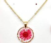 Real pressed flower round pendant necklace in clear resin. Lightweight, nature-inspired, and handcrafted for a unique botanical jewelry statement.