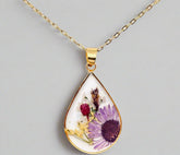 Teardrop necklace with real pressed dried flowers in resin. Unique floral charm with stainless steel chain and copper frame. Nature-inspired and handcrafted.