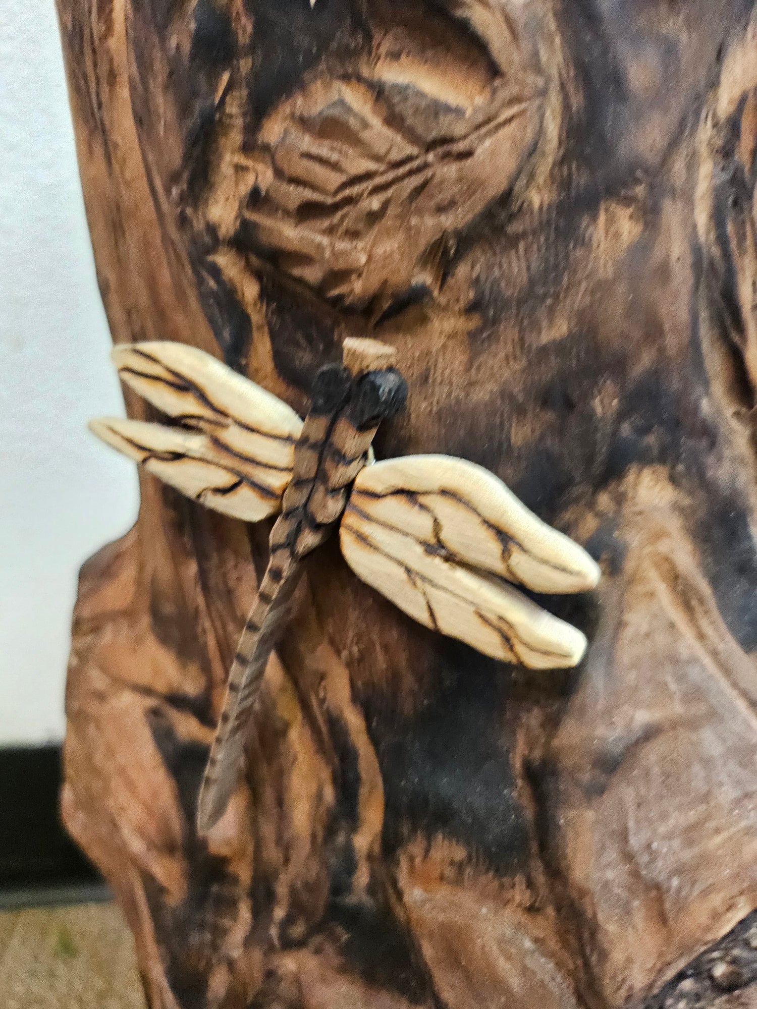 The Hand-Carved Dragonfly Outdoor Planter and Solar Light Wood Spirit in Solid Walnut (30" x 10"). 100% handmade, each piece is unique and perfect for home decor. The natural walnut grain and artisanal craftsmanship add rustic charm, making it a standout decorative piece for any space.