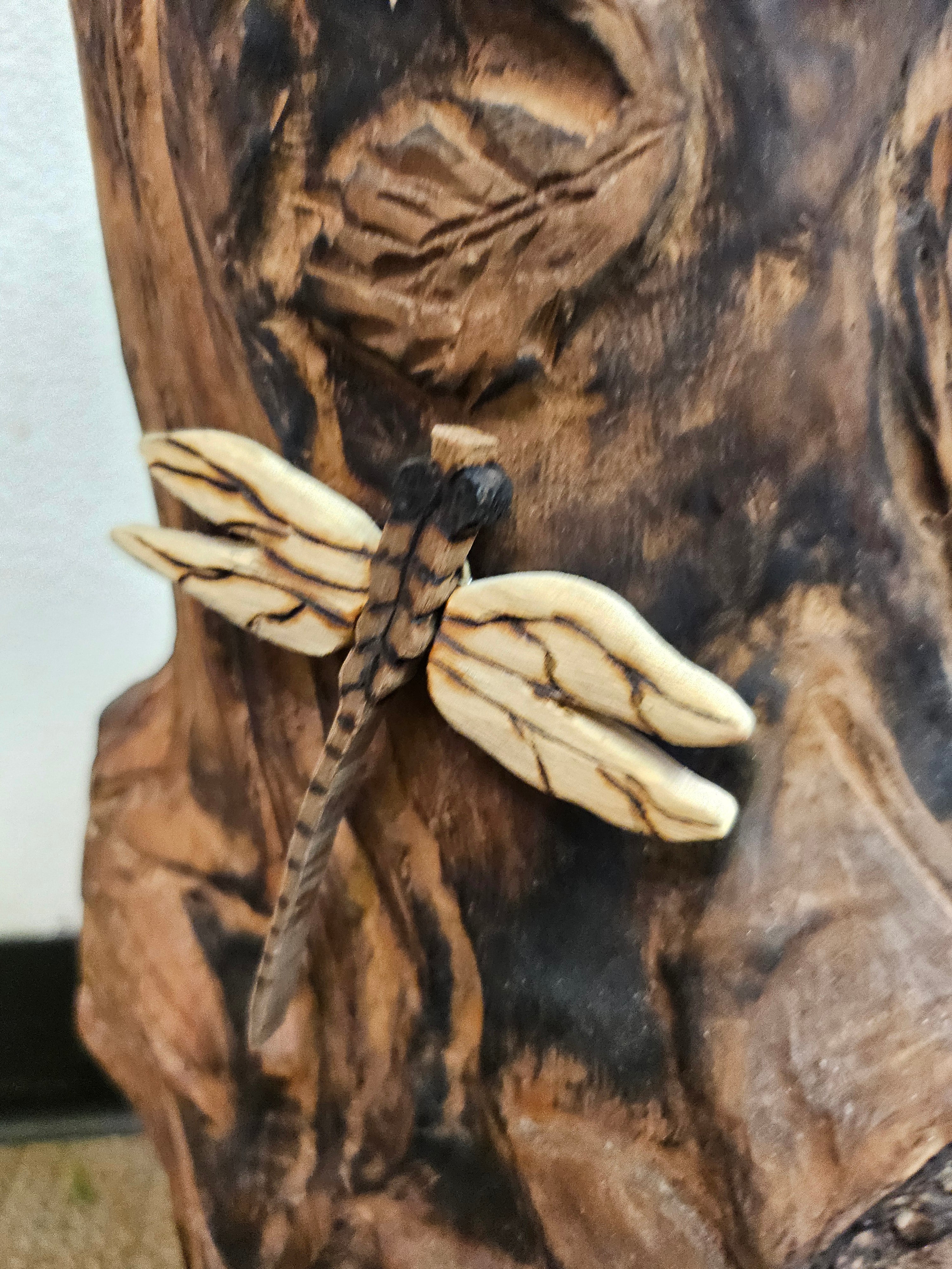 The Hand-Carved Dragonfly Outdoor Planter and Solar Light Wood Spirit in Solid Walnut (30" x 10"). 100% handmade, each piece is unique and perfect for home decor. The natural walnut grain and artisanal craftsmanship add rustic charm, making it a standout decorative piece for any space.