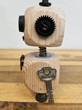 The Handmade Wood Block Steampunk Robot is a unique, decorative figurine crafted from wood with an aged, rustic look. Each robot is one-of-a-kind for display only. Includes a heart-shaped balloon. Available in various sizes, it&