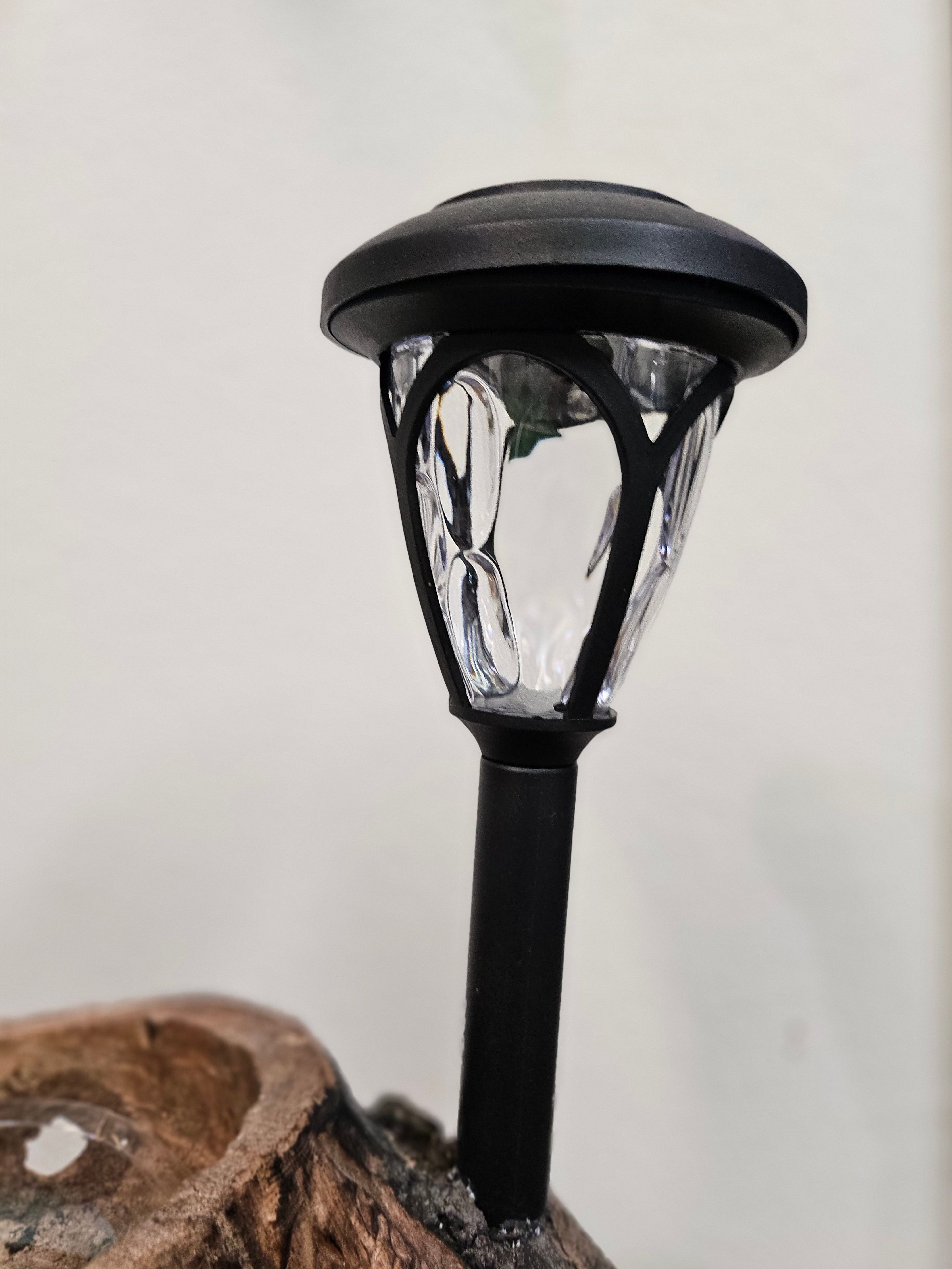 The Hand-Carved Dragonfly Outdoor Planter and Solar Light Wood Spirit in Solid Walnut (30" x 10"). 100% handmade, each piece is unique and perfect for home decor. The natural walnut grain and artisanal craftsmanship add rustic charm, making it a standout decorative piece for any space.