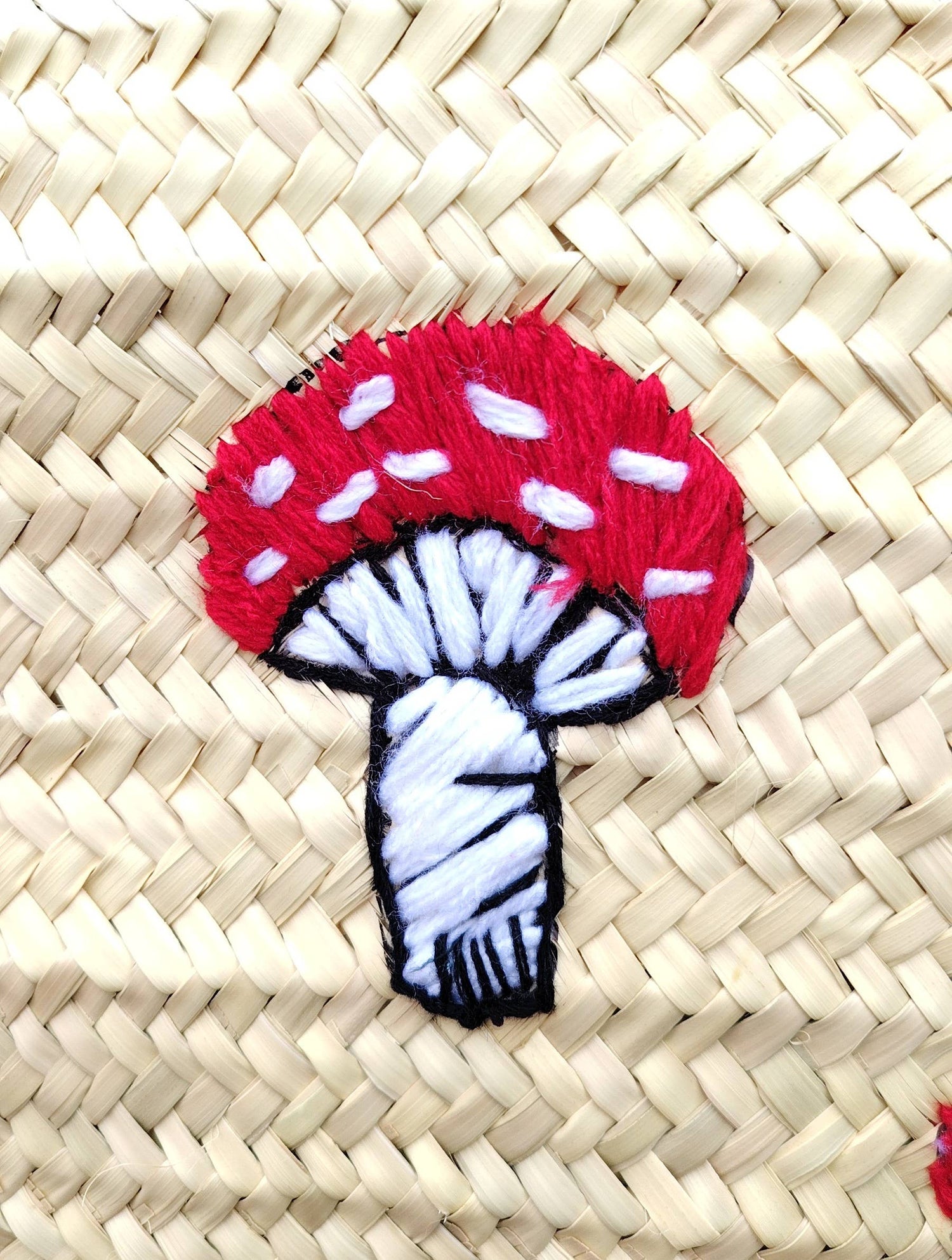 Whimsical straw tote with red mushroom embroidery, leather handles & eco-friendly palm straw. Perfect for market trips, beach days, or unique gifting.
