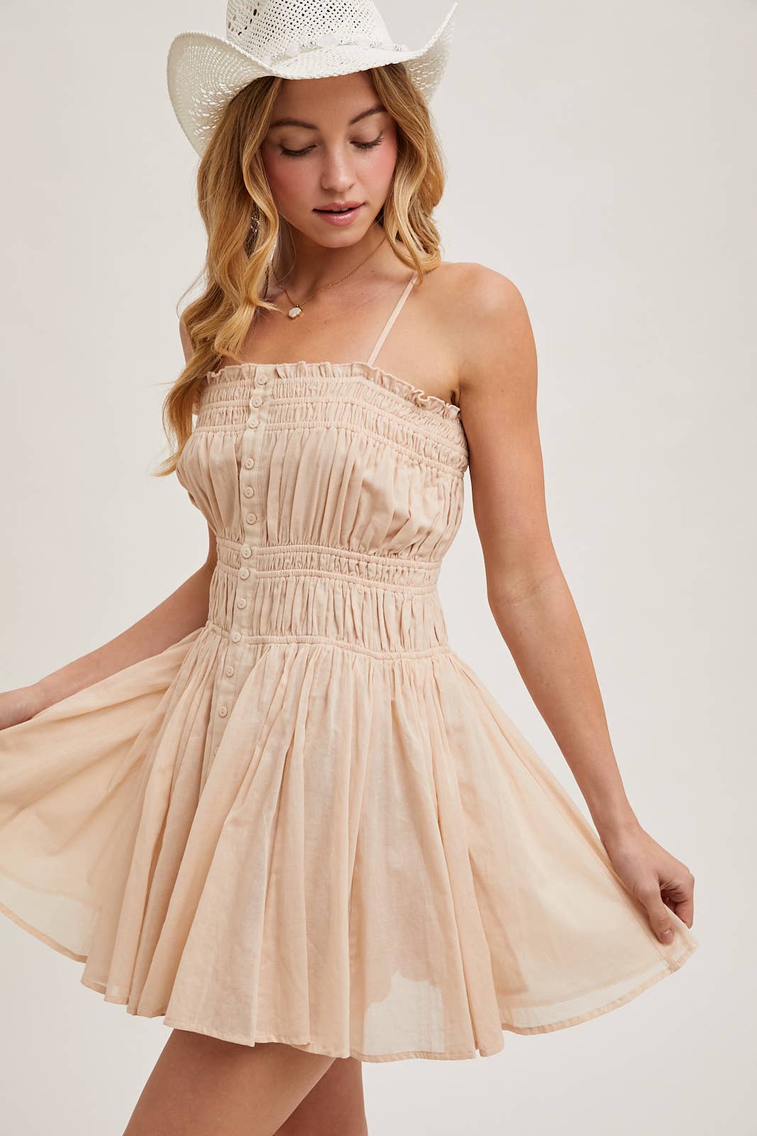 Smocked mini dress with button-down front, adjustable straps & breezy skirt. A flattering, lightweight style perfect for summer days & casual outings.