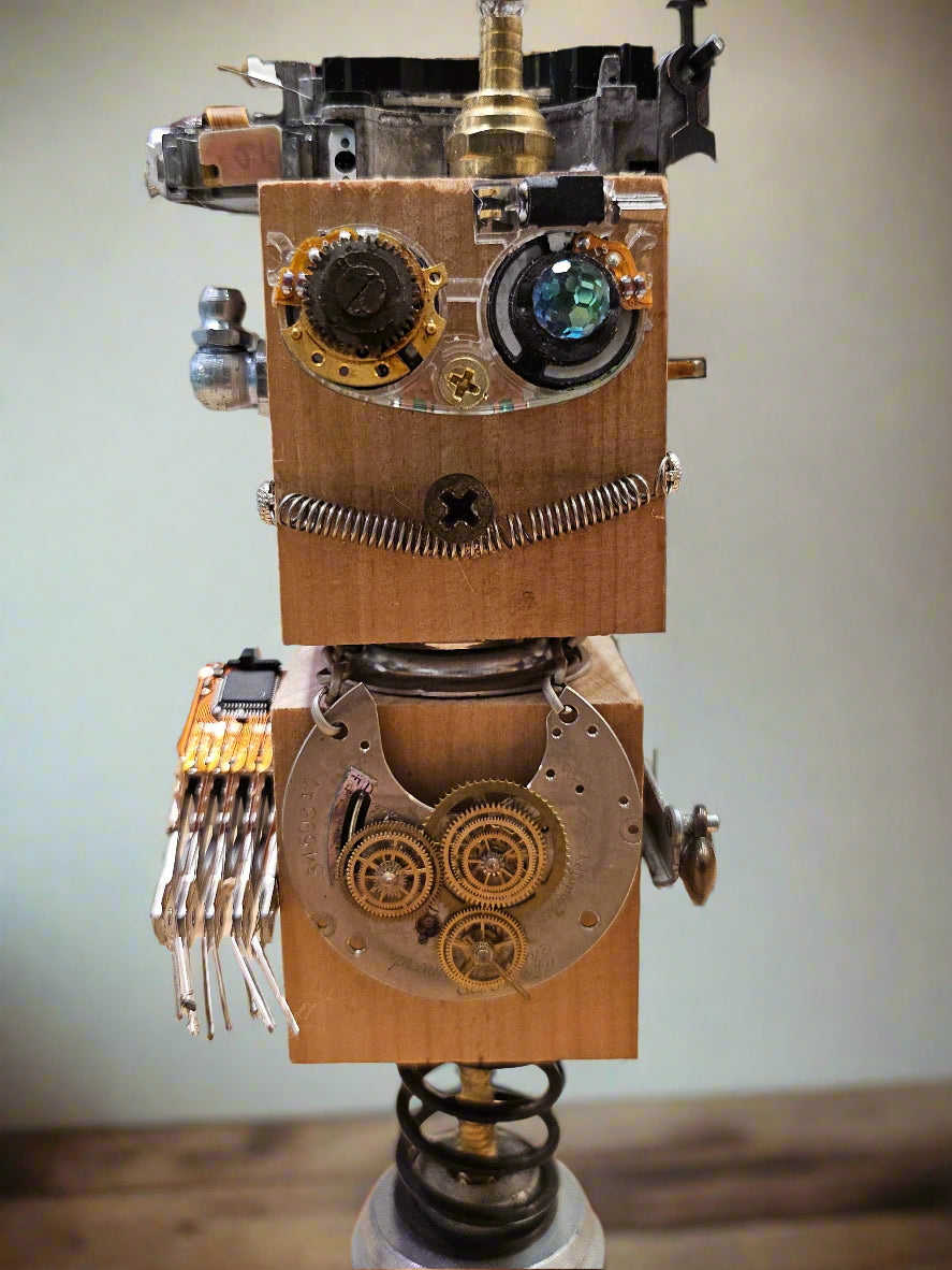The Handmade Wood Block Steampunk Robot is a unique, decorative figurine crafted from wood with an aged, rustic look. Each robot is one-of-a-kind for display only. Includes a heart-shaped balloon. Available in various sizes, it&