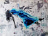 Float 5 is a 36"x48" mixed media artwork blending surrealism and street art. Featuring a figure floating mid-air in a blue gown against a gritty urban backdrop, it explores themes of escape and transcendence. Perfect for modern spaces, this visually striking piece adds depth and intrigue, pairing beautifully with a Palm.