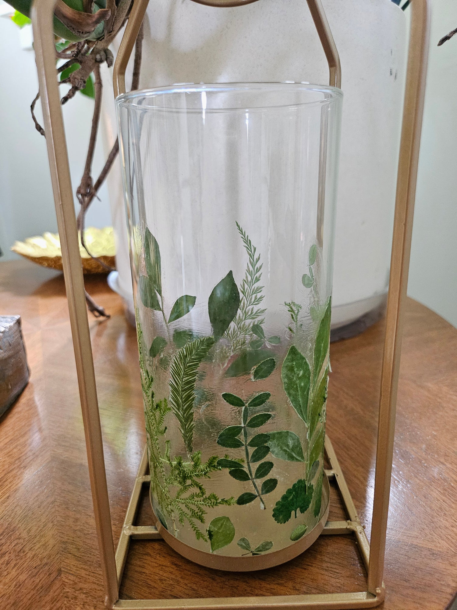 Verdant Canopy Gold Lantern features real pressed ferns and greenery in a gold frame, bringing forest charm and calming light to any indoor or outdoor space.