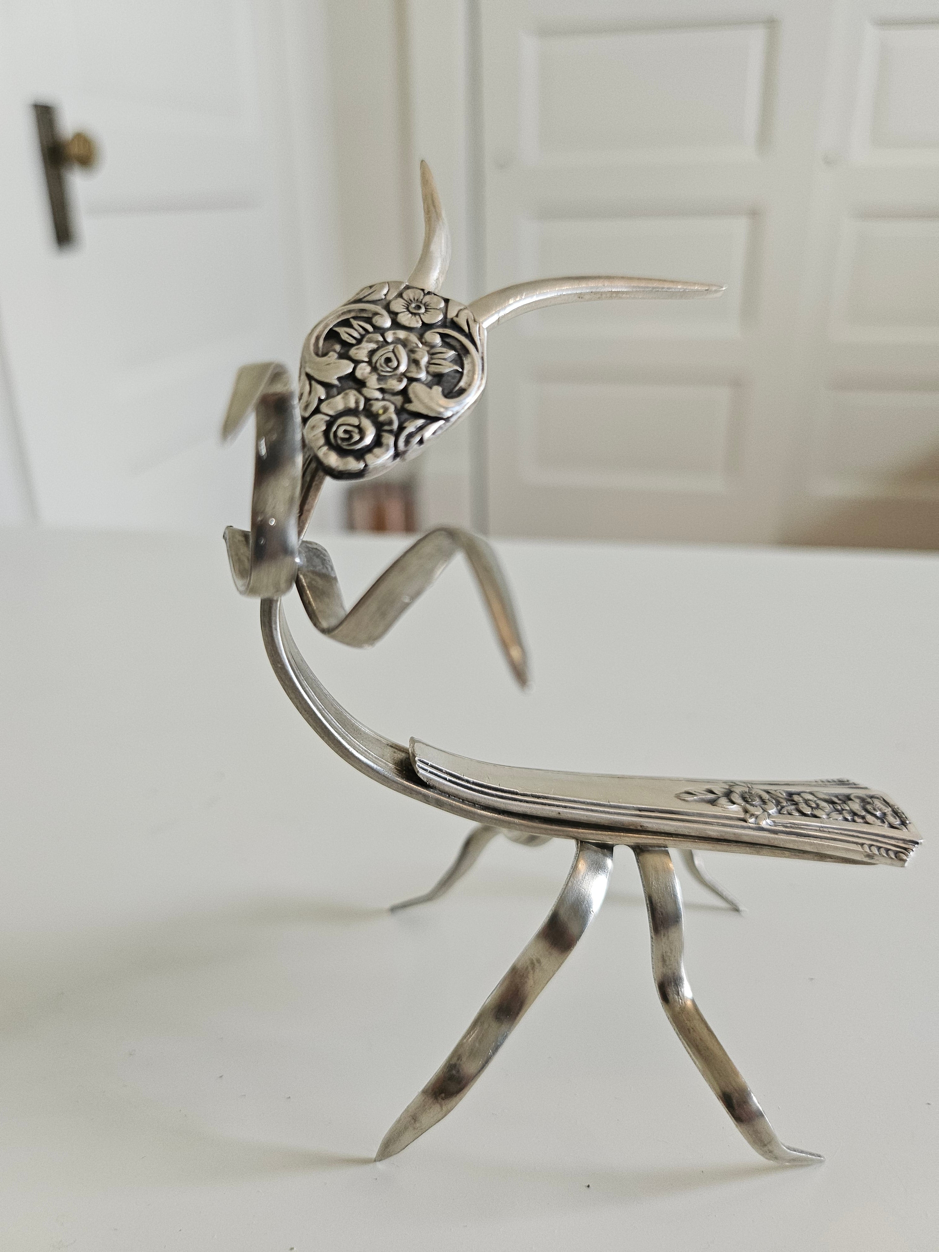 Handcrafted 5" x 4" praying mantis sculpture made from vintage silverware. Unique, whimsical art with gemstone accents and aged patina for mindful décor.