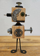 The Handmade Wood Block Steampunk Robot is a unique, decorative figurine crafted from wood with an aged, rustic look. Each robot is one-of-a-kind for display only. Includes a heart-shaped balloon. Available in various sizes, it&