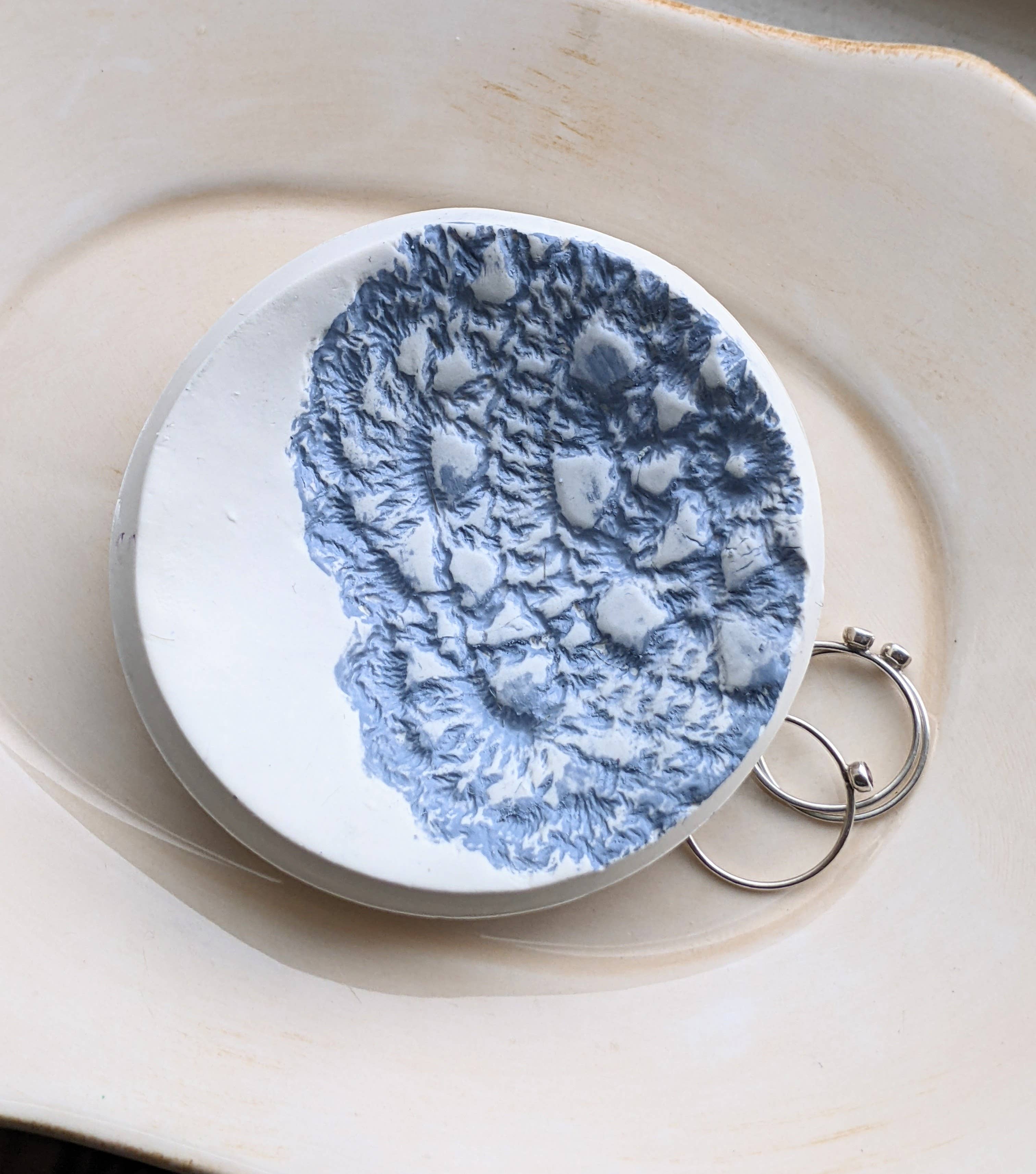 Handmade polymer clay dish with a green lace impression. Perfect as a jewelry or ring holder. Durable, decorative, and one-of-a-kind. Not food safe.