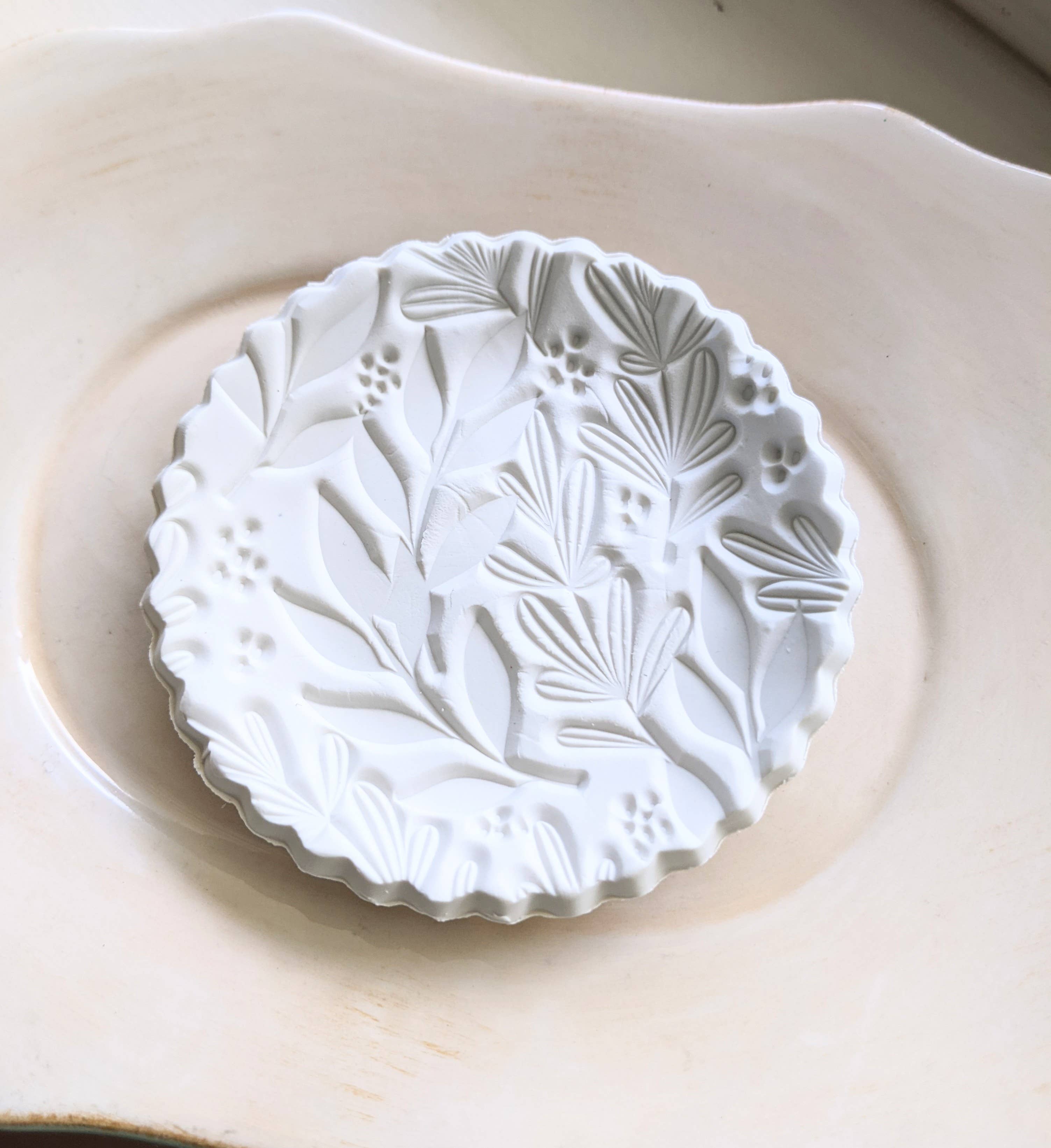 Handmade white polymer clay dish with a botanical impression. Perfect for holding rings, earrings, or small treasures. Unique, durable, and decorative.