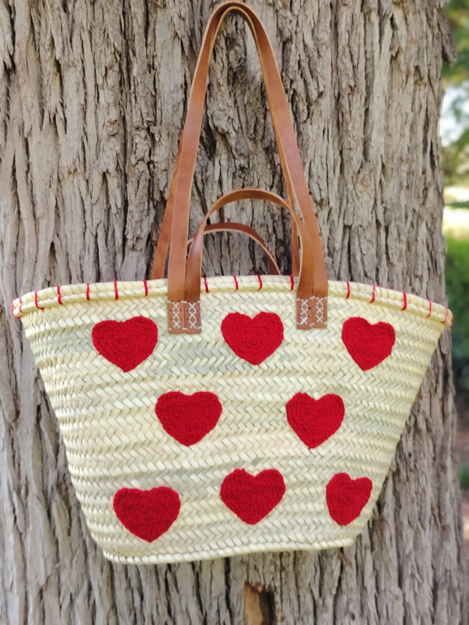 Handwoven straw tote with red crochet hearts and leather handles. Eco-friendly, artisan-made, and perfect for markets, gifting, or seasonal outings.