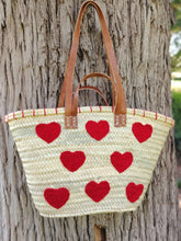 Handwoven straw tote with red crochet hearts and leather handles. Eco-friendly, artisan-made, and perfect for markets, gifting, or seasonal outings.
