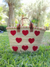 Handwoven straw tote with red crochet hearts and leather handles. Eco-friendly, artisan-made, and perfect for markets, gifting, or seasonal outings.
