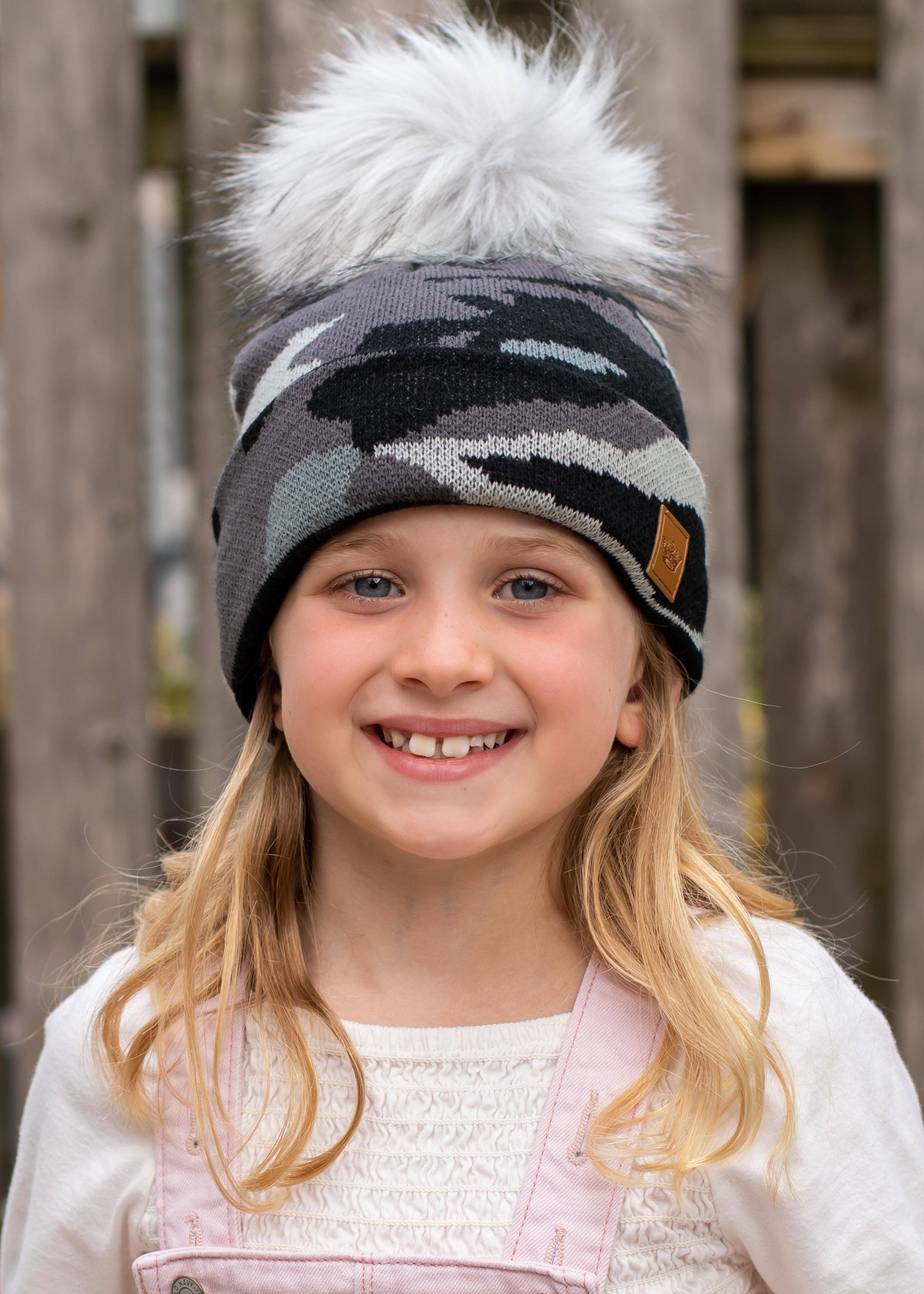 Kids grey camo knit hat with faux fur pom—cozy, durable, and playful. Perfect for autumn & winter adventures, keeping little ones warm in style.