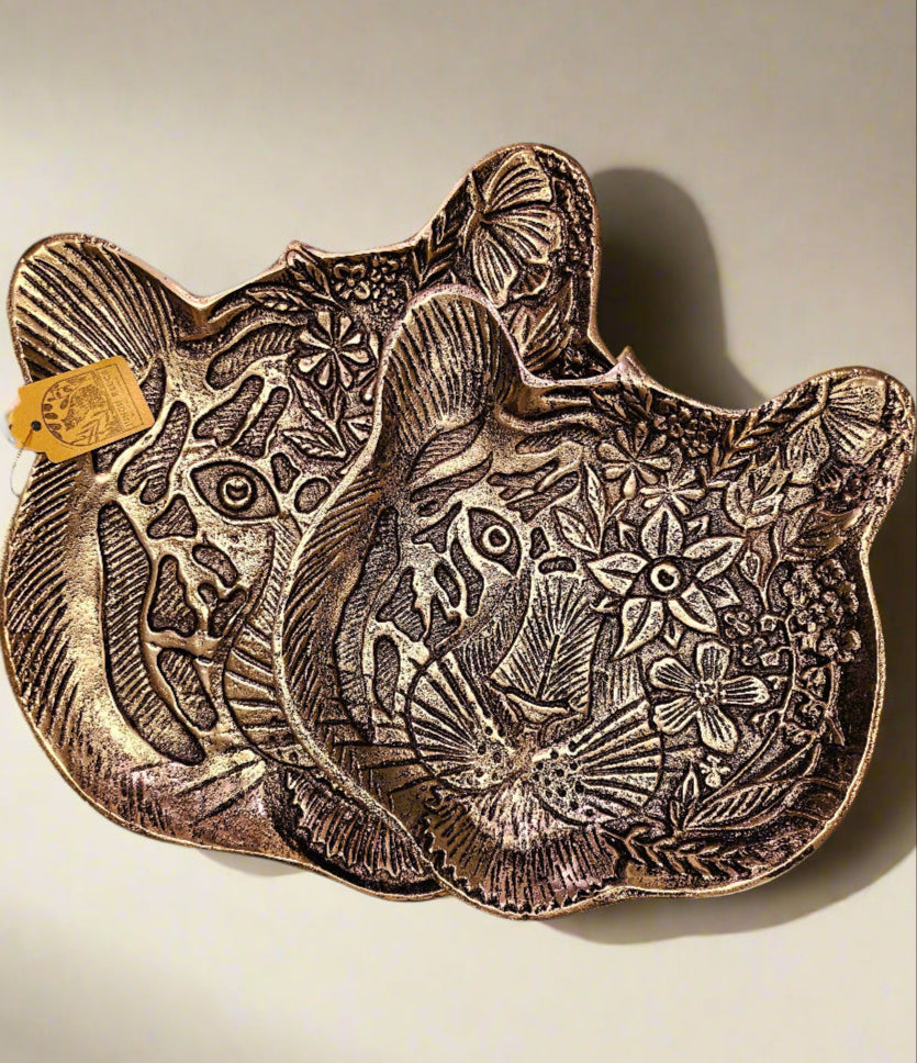 The Tiger Embossed Metal Tray is a luxurious and durable 16 cm x 14.5 cm catchall dish with a golden finish and intricate tiger head design. Perfect for organizing jewelry, keys, or coins, it adds a regal touch to any space. Ideal as a functional decor piece or a thoughtful gift for art and animal lovers.