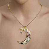 Moon-shaped pendant necklace with real pressed flowers and shell in resin, set in 18K gold-plated brass. Unique, handmade celestial floral jewelry.