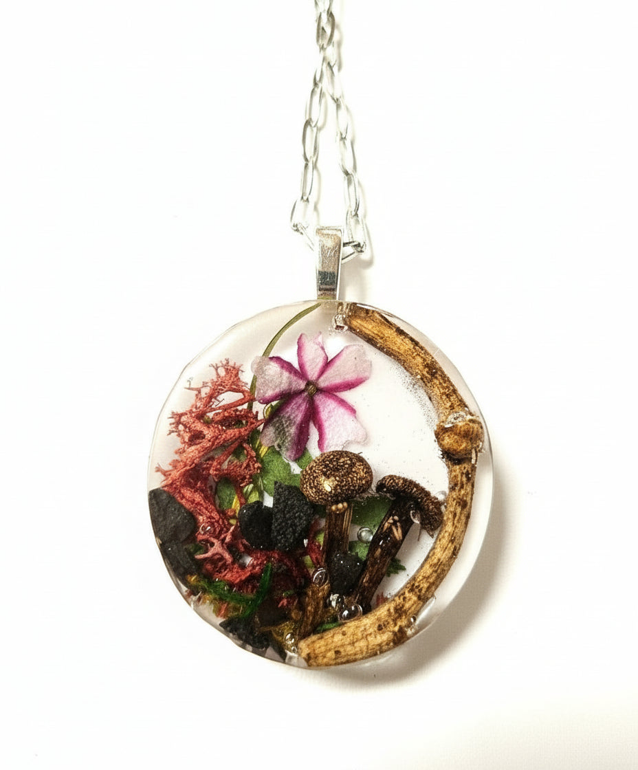 Handcrafted terrarium necklace featuring preserved botanicals and moss, creating a miniature garden you can wear. Each piece is one of a kind.
