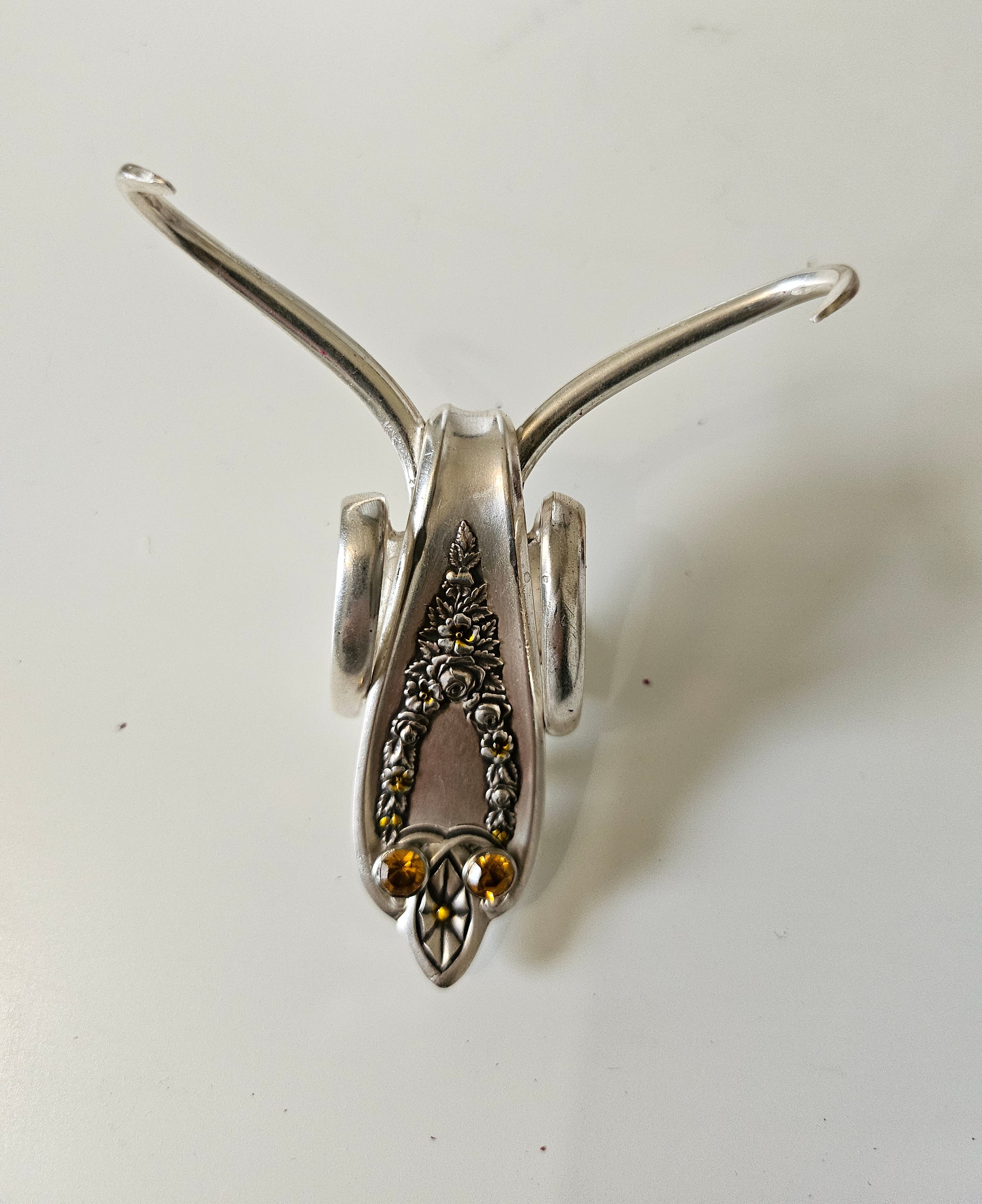 The Jeweled Lucky Fork Cricket is a whimsical, handcrafted sculpture made from repurposed vintage silverware. Each unique piece, shaped from antique forks, captures the charm of crickets—symbols of luck, prosperity, and protection. Adorned with jewels and aged patina, these one-of-a-kind collectibles add artistry, history, and positive energy to any space.