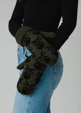 Olive skull patterned knit mittens with cozy fleece lining. Made from 100% acrylic for warmth and durability. Bold winter style pairs with matching hat.
