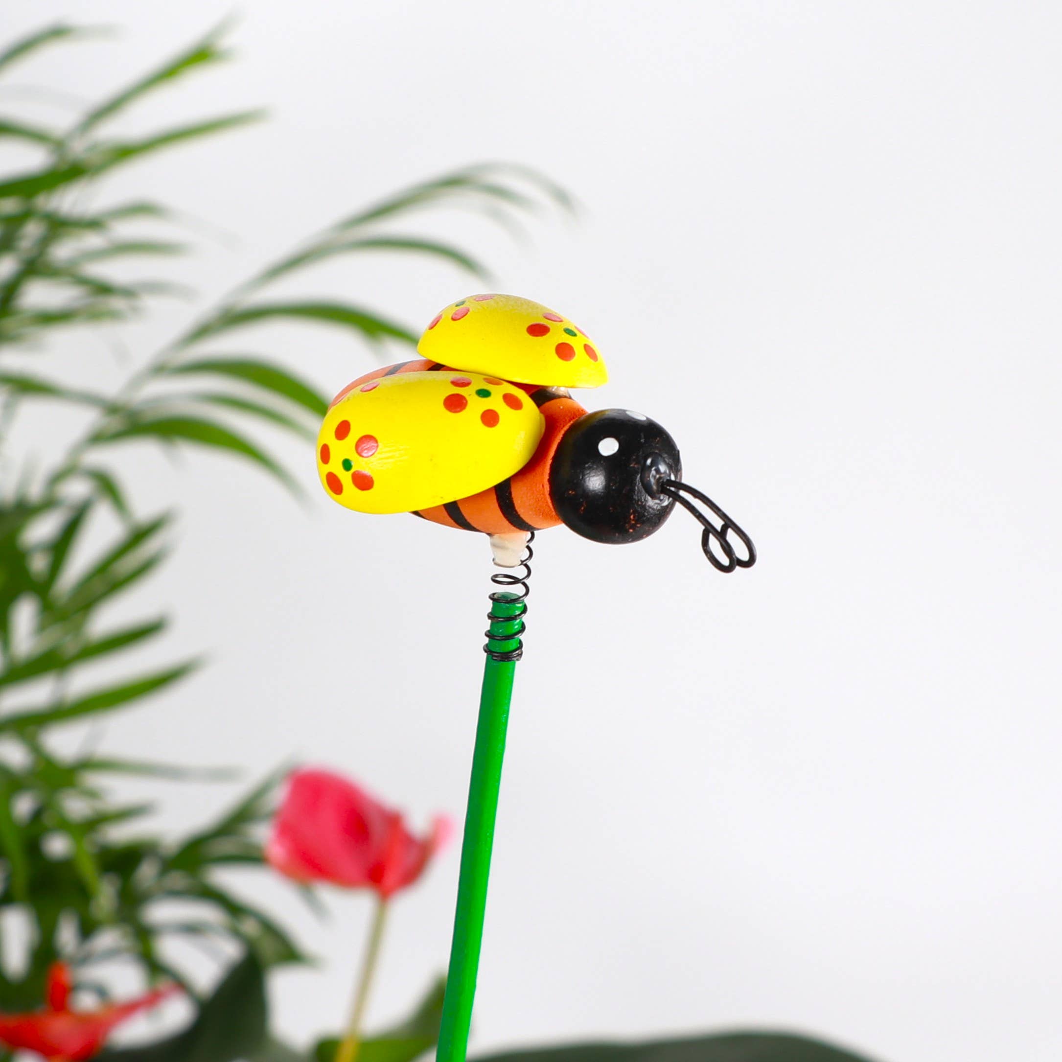 Whimsical bee plant picks with wooden bees on springs. Adds playful movement to houseplants and gardens. Adjustable 19" stake. No plants included.