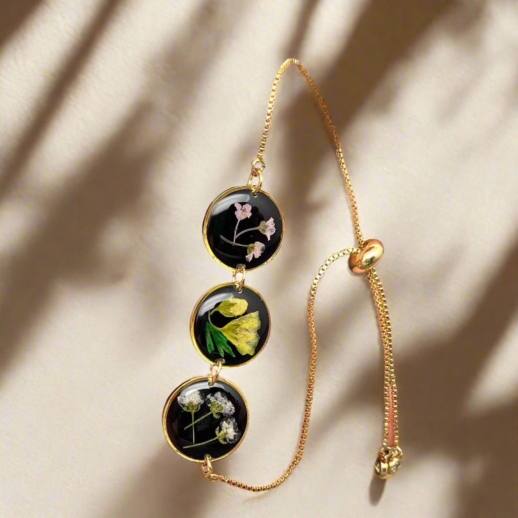 Wildflower Whisper Bracelet with real pressed flowers in resin and adjustable stainless-steel chain. Unique, hypoallergenic, and perfect for everyday nature lovers.