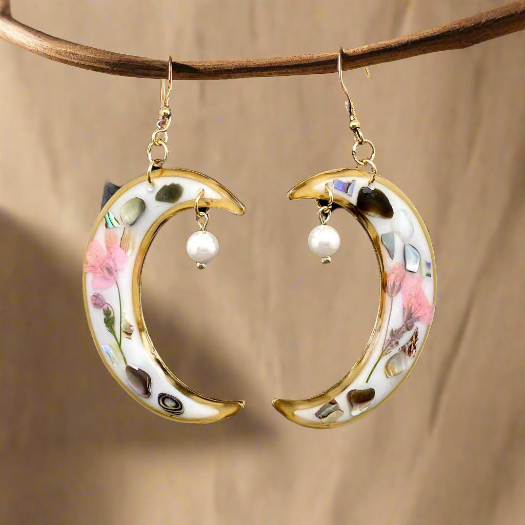 Lunar Bloom earrings with real pressed flowers in resin and 18K gold-plated brass. Bold, handmade floral statement jewelry in a 40mm x 66mm drop design.