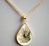 Teardrop necklace with real pressed dried flowers in resin. Unique floral charm with stainless steel chain and copper frame. Nature-inspired and handcrafted.