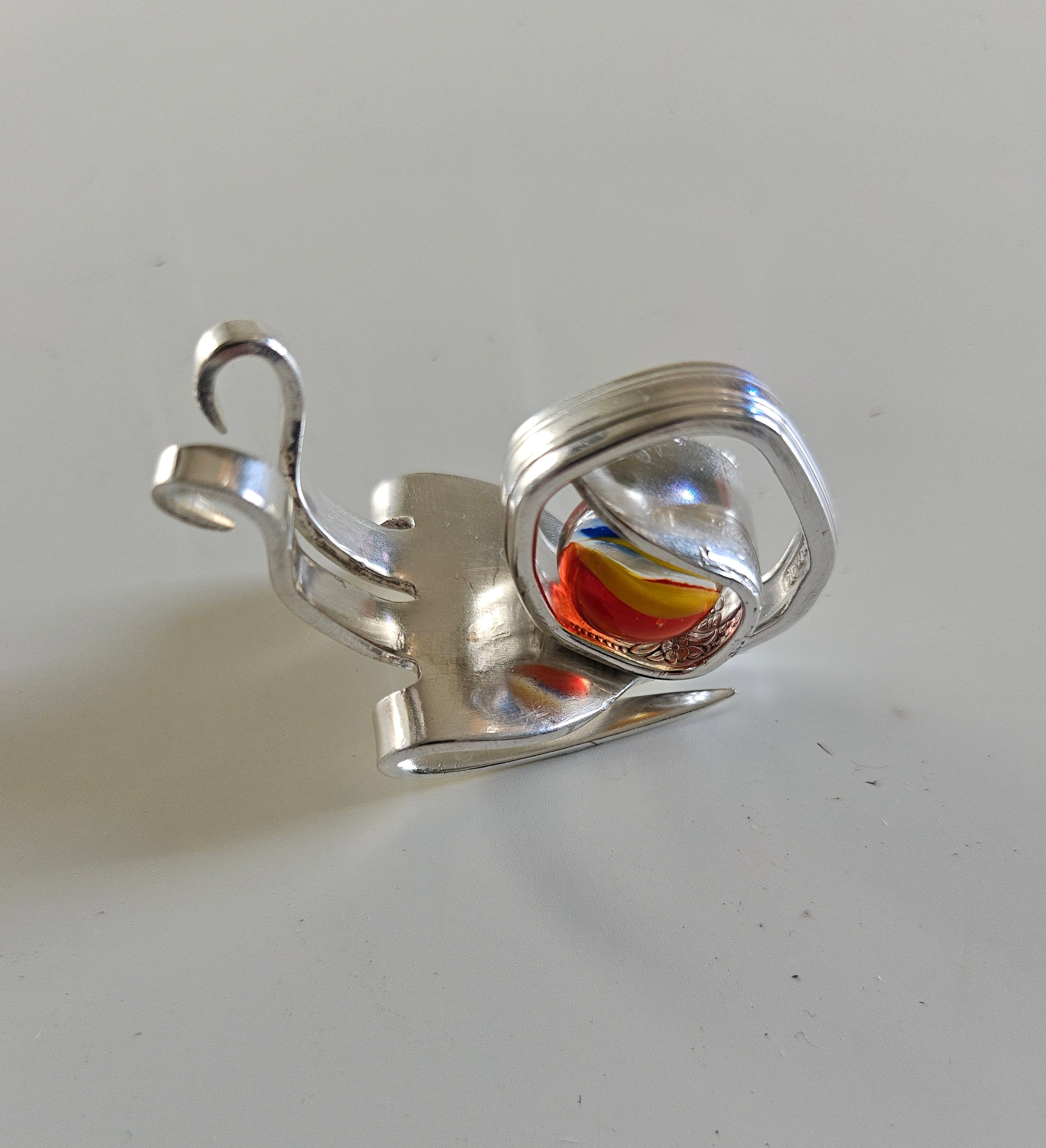 Handcrafted from vintage silverware, these whimsical snails feature shimmering glass orb shells—each a one-of-a-kind symbol of patience and charm.