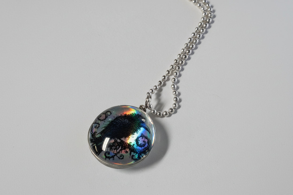 Handcrafted nature scene necklaces with real botanicals in iridescent and clear resin. Unique, wearable landscapes on chain or satin cord.