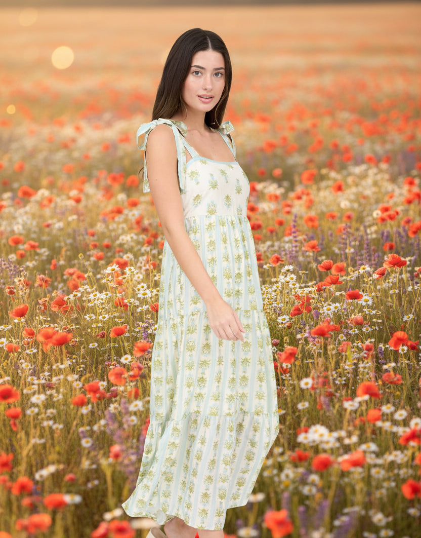 Romantic floral border print midi dress with scalloped neckline, waist tie, and flowing silhouette. Feminine, vintage-inspired, and effortlessly elegant.