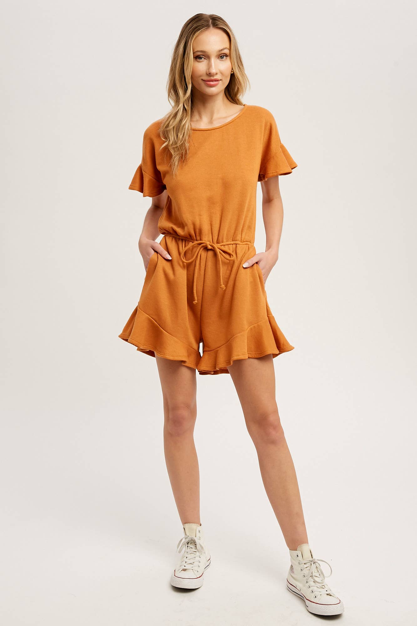 Soft French terry romper with ruffled sleeves, elastic waist, pockets & back button closure. Comfy, cute, and perfect for sunny days or casual outings.