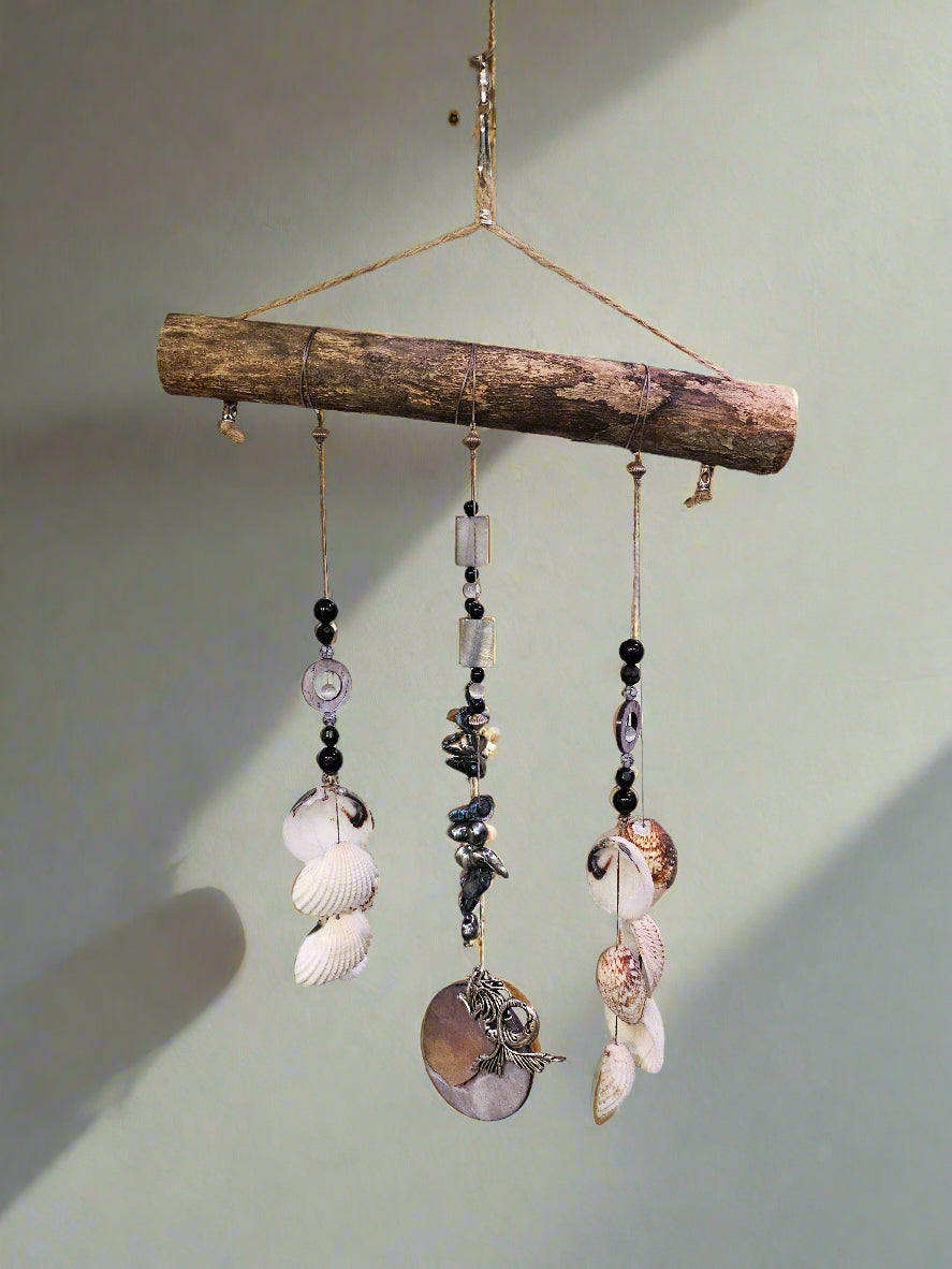 Add coastal charm to your space with the Shell & Bead Bohemian Suncatcher. Handcrafted with natural shells, semi-precious stones, and beads, it captures sunlight to create a stunning display of light and texture, perfect for windows, gardens, or as a unique, nature-inspired gift.