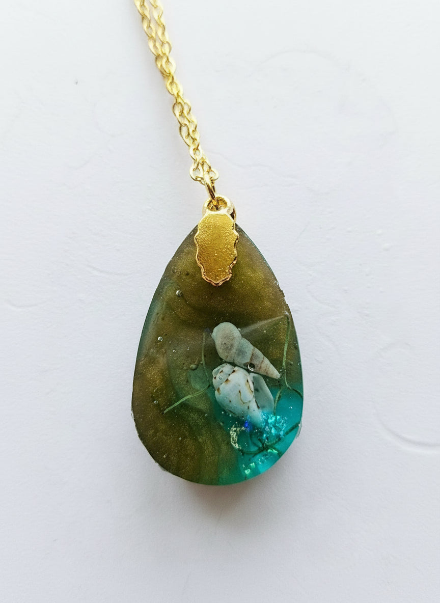 Sea Life Resin Pendant Necklaces by artist KStonely featuring shells, fish, jellyfish, and sea life miniatures in dreamy blue, brown, and gold ocean-inspired resin.