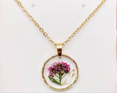 Real pressed flower round pendant necklace in clear resin. Lightweight, nature-inspired, and handcrafted for a unique botanical jewelry statement.